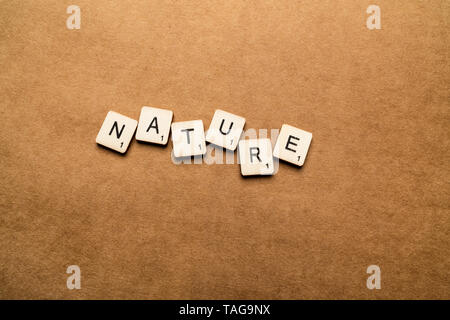 LONDON, UK, 24. Mai 2019: Das Wort Natur Dinkel mit hölzernen Buchstabensteine über eine braune strukturierten Hintergrund Stockfoto