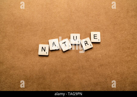 LONDON, UK, 24. Mai 2019: Das Wort Natur Dinkel mit hölzernen Buchstabensteine über eine braune strukturierten Hintergrund Stockfoto