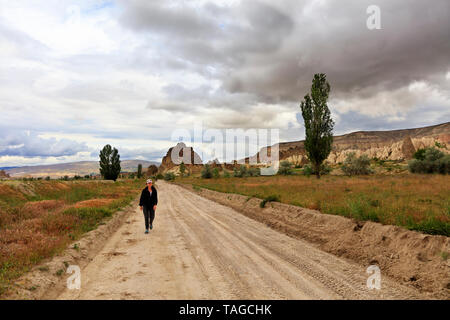 Auf einem unbefestigten sandigen Weg, eine müde Touristen zurück nach Hause von einer Wanderung durch die felsigen Täler Kappadokiens. Stockfoto