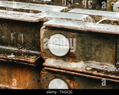 Mutter , Schraube Schraube befestigt in alten Zink Rusty Grunge verzinktem Wellblech. Abblätternde Rissbildung urigen alten Metall Hintergrund und Rost Textur. Stockfoto