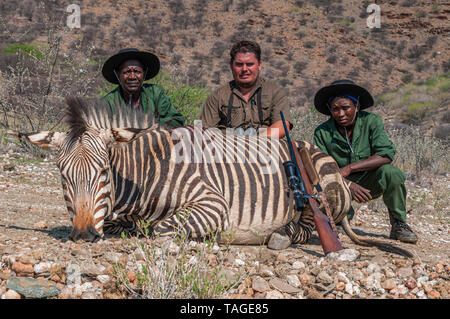 Jäger stellen mit ihrer Trophäe, Mountain Zebra auf einer privaten Farm in Namibia. Stockfoto