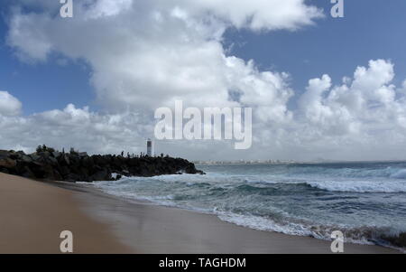 Buddina, Australien - 21.April 2019. Menschen entspannend auf buddina Strand breakwall (Sunshine Coast, Queensland, Australien) auf einem sonnigen, aber bewölkten Tag. Stockfoto