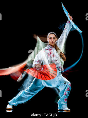 Eine chinesische Frau partacticing Tai Chi Chuan Tadjiquan Körperhaltung studio Schuß auf schwarzen Hintergrund mit Licht malen Effekt isoliert Stockfoto