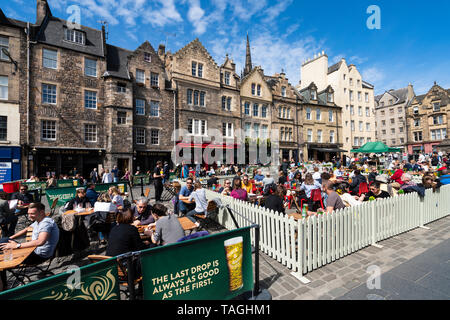 Viele Menschen trinken in Bars im Freien bei schönem Wetter am Grassmarket in der Altstadt von Edinburgh, Schottland, Großbritannien Stockfoto