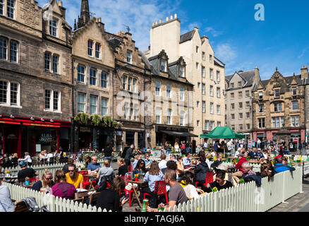 Viele Menschen trinken in Bars im Freien bei schönem Wetter am Grassmarket in der Altstadt von Edinburgh, Schottland, Großbritannien Stockfoto