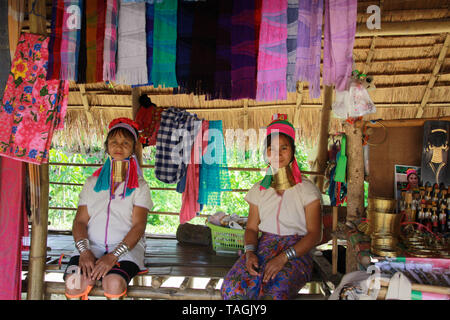 LONGNECK KAREN DORF, THAILAND - Dezember 17. 2017: Zwei lange Hals Frauen vor einer Bambushütte sitzen Stockfoto