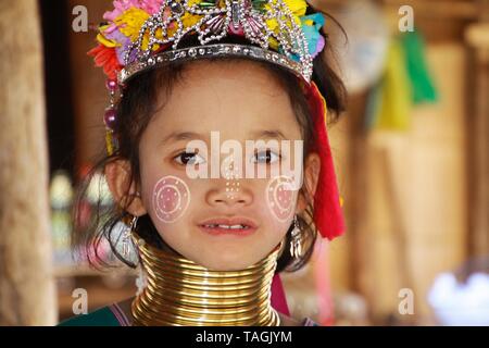 LONGNECK KAREN DORF, THAILAND - Dezember 17. 2017: Nahaufnahme, Porträt der jungen lange Hals Mädchen mit thanaka Kinderschminken und Messing Gewindehälften Stockfoto