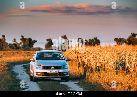 Gomel, Weißrussland - 14. September 2016: Volkswagen Polo Vento Limousine Parkplatz in der Nähe von Landstraße im Herbst Feld im sonnigen Abend. Stockfoto