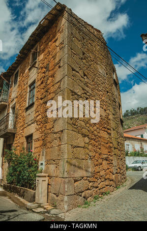 Alte Stein zwei-stöckige Haus mit Holztür, in eine einsame Gasse in Unhais da Serra. Ein kleines Dorf an der Serra da Estrela Ridge in Portugal. Stockfoto