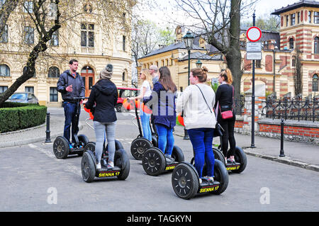 Besucher, Touristen, auf Segways, Hören zu einem Tourguide während einer Führung der Krakauer Altstadt. Polen. Stockfoto