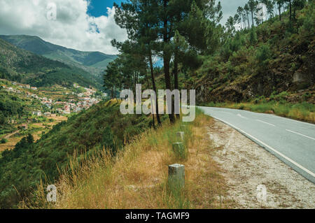 Road vorbei durch die hügelige Landschaft und das Dorf im Tal bei Alvoco da Serra. Ein niedliches Dorf auf einem steilen Tal im Osten Portugal festhalten. Stockfoto