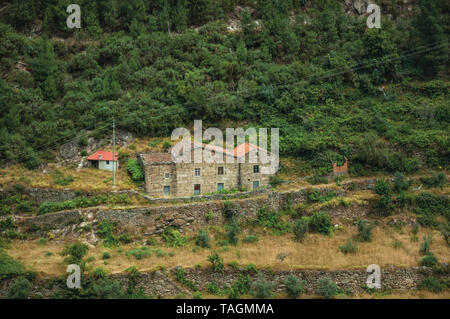 Hügelige Landschaft mit terrassierten Feldern und ein Landhaus in der Nähe von Alvoco da Serra. Ein niedliches Dorf auf einem steilen Tal im Osten Portugal festhalten. Stockfoto