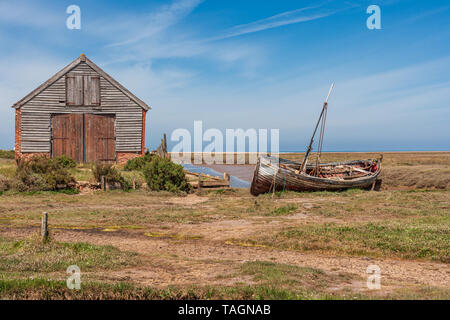 Blick auf die alte Kohle Scheune und alten hölzernen Boot an thornham Hafen an der Küste von North Norfolk Stockfoto