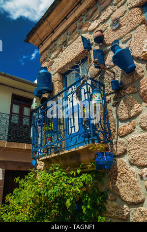 Bügeleisen Geländer Balkon mit vielen blauen Pfannen auf Stein Haus Fassade an Alvoco da Serra. Ein niedliches Dorf auf einem steilen Tal im Osten Portugal festhalten. Stockfoto