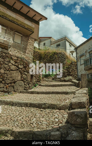Fassade der alten Häuser aus Stein gepflasterten Gasse am Hang mit den Schritten an Alvoco da Serra. Ein niedliches Dorf auf einem steilen Tal im Osten Portugal festhalten. Stockfoto