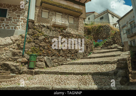 Fassade der alten Häuser aus Stein gepflasterten Gasse am Hang mit den Schritten an Alvoco da Serra. Ein niedliches Dorf auf einem steilen Tal im Osten Portugal festhalten. Stockfoto