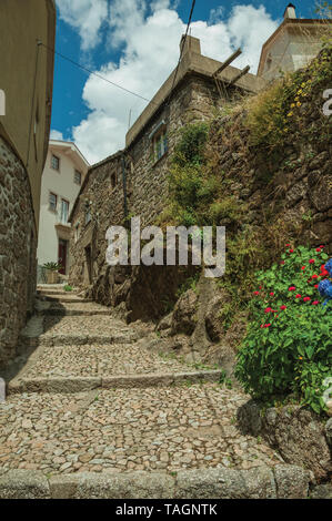 Alte Steinmauer und Häuser in kopfsteingepflasterten Gasse am Hang mit den Schritten an Alvoco da Serra. Ein niedliches Dorf auf einem steilen Tal im Osten Portugal festhalten. Stockfoto