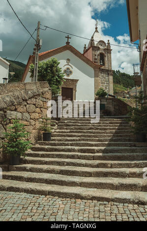 Alte Landschaft Kirche Fassade und Turm auf der Steintreppe an Alvoco da Serra. Ein niedliches Dorf auf einem steilen Tal im Osten Portugal festhalten. Stockfoto