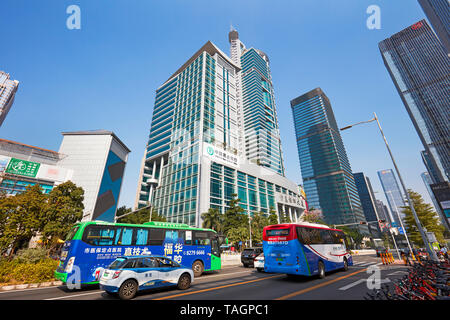 Elektrobusse und Taxis fahren die Straße hinunter im zentralen Geschäftsviertel von Futian. Shenzhen, Provinz Guangdong, China. Stockfoto