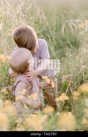 Big Bruder und Schwester Hug in einem Feld Stockfoto