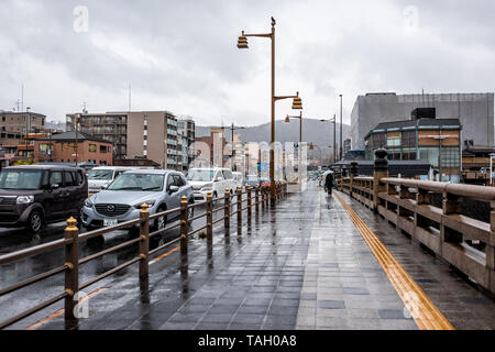 Kyoto, Japan - 9. April 2019: Gojo-dori Street Bridge in der Nähe von Gion Distrikt während der regnerischen bewölkten Tag und viele Autos im Verkehr mit Blick auf den Bürgersteig Stockfoto