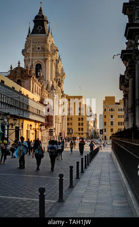 Lima, Peru - 21. April 2018: Blick auf den Marktplatz und die Kathedrale an sonnigen Nachmittag mit vielen Touristen aus Seitenstraße Stockfoto