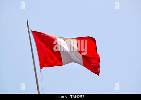Nationalflagge von Peru mit kein Wappen weht im Wind vor blauem Himmel Stockfoto