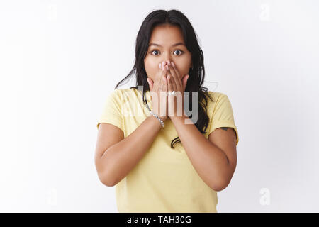 Schockiert und betroffen betäubt junge asiatische Frau keuchend von schüttelte, Hände auf Mund zu knallen die Augen erschrocken auf der Suche mit Empathie und Sorge, stehend Stockfoto