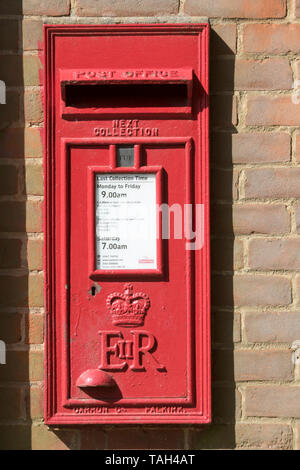 Red Royal Mail Post Box in Ziegel Wand an Kante, Hertfordshire, Vereinigtes Königreich. Stockfoto