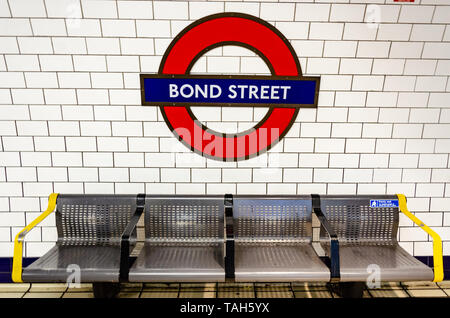Eine Metallbank auf dem Bahnsteig an der Londoner U-Bahn-Station Bond Street. Stockfoto