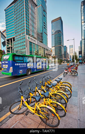 Stadt Fahrräder zum Mieten auf der Straße im zentralen Geschäftsviertel Futian geparkt. Shenzhen, Guangdong Province, China. Stockfoto