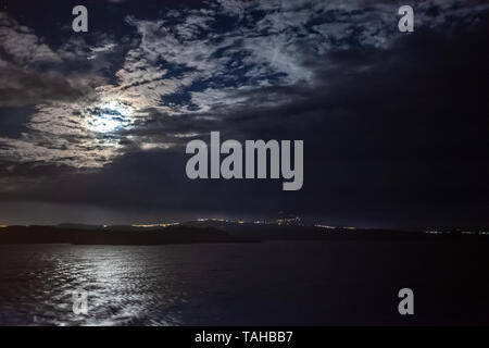 Mond teilweise durch Wolken über der Insel Stein am Rhein in der Nähe von Athen, Griechenland ausgeblendet Stockfoto