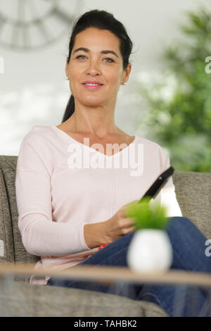 Frau mit der TV-Fernbedienung Stockfoto