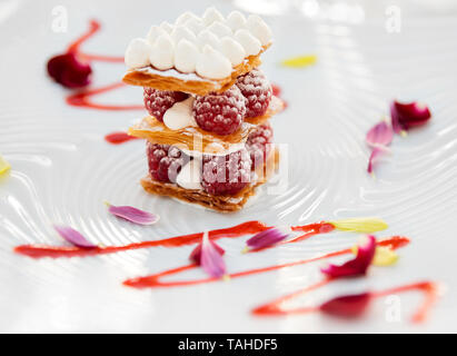 Scheibe der Mille-feuille Torte mit Himbeeren und süßen Soße auf Porzellan Platte Stockfoto