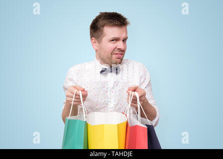 Junger Mann mit farbigem Papier Pakete mit Geschenken. Stockfoto