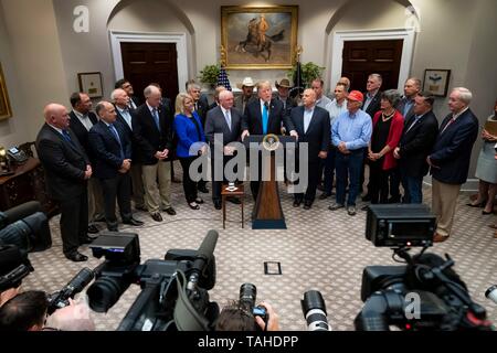 Us-Präsident Donald Trump verbunden von Landwirtschaftsminister Sonny Perdue, Links, liefert Erläuterungen zur Unterstützung der Landwirte und Viehzüchter während einer Veranstaltung im Roosevelt Raum des Weißen Hauses 23. Mai 2019 in Washington, DC. Stockfoto