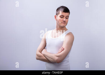 In der Nähe von glücklichen Menschen in Tanktop mit verschränkten Armen vor weißem Hintergrund Stockfoto