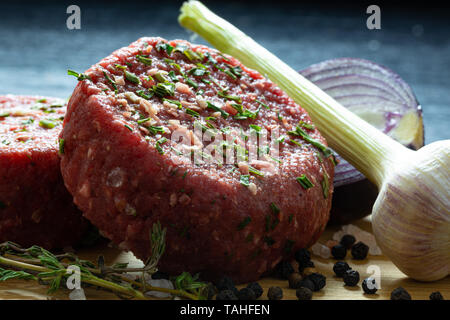 Beef Tatar burger Patty mit Zwiebel, Knoblauch, Thymian, Pfeffer und Himalaya Kristallsalz. Stockfoto