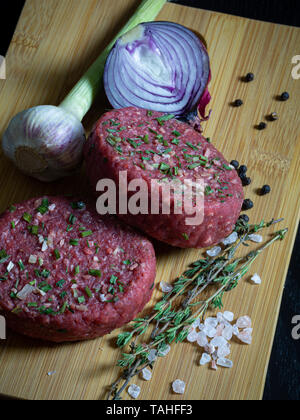 Beef Tatar burger Patty mit Zwiebel, Knoblauch, Thymian, Pfeffer und Himalaya Kristallsalz. Stockfoto