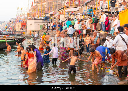Varanasi, Indien, 27. März 2019 - Die bunte traditionelle Kleidung und der religiösen Ritual der baden in den Ganges von der alten Stockfoto
