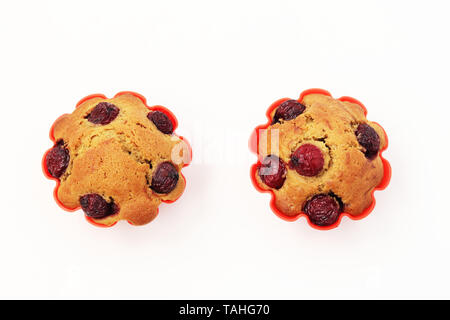 Cupcakes mit einer Kirsche auf einem weißen Hintergrund, Ansicht von oben Stockfoto