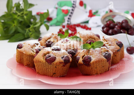 Cupcakes mit Kirschen sind auf einem Schild auf einem weißen Hintergrund befindet Stockfoto