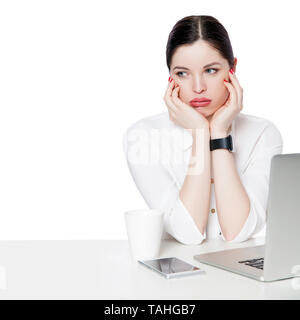 Portrait von nachdenklich brunette Geschäftsfrau im weißen Hemd sitzt mit Laptop, Ihr Gesicht zu berühren, wegsehen, verwirrt und denken, was zu tun Stockfoto