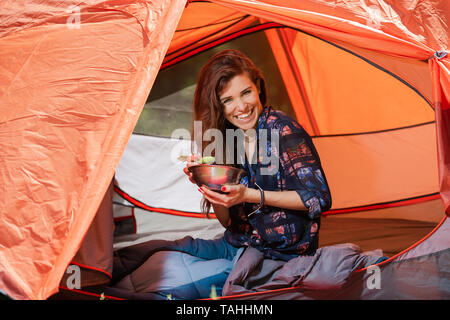 Ihnen gerne touristische junge Frau das Mittagessen im Zelt Stockfoto