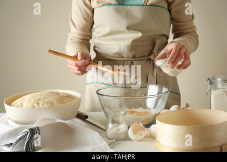 Junge Frau Zubereitung Teig für Brot am Tisch Stockfoto