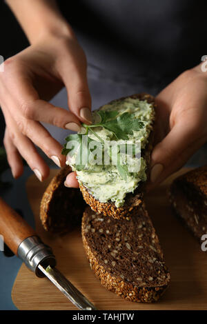 Junge Frau mit Stück frisches Brot mit Butter, Nahaufnahme Stockfoto