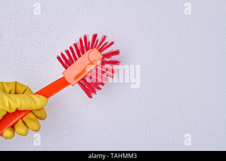 Hand, die WC-Bürste. Hand in gelben Gummihandschuh holding Bürste mit Griff aus Kunststoff. Platz für Text. Stockfoto