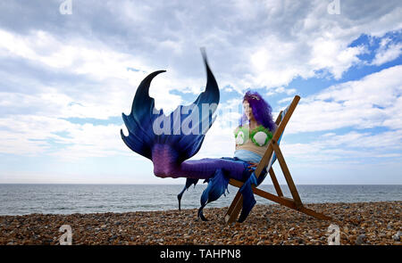 Mermaid Jasz Vegas Posen am Strand während das wechselhafte Wetter in Brighton als Sea Life Brighton die Öffnung ihrer Tag/Nacht erleben. Stockfoto