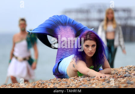 Mermaid Jasz Vegas verbunden ist, die von anderen Meerjungfrauen am Strand während das wechselhafte Wetter in Brighton als Sea Life Brighton kennzeichnet die Öffnung ihrer Tag/Nacht erleben. Stockfoto