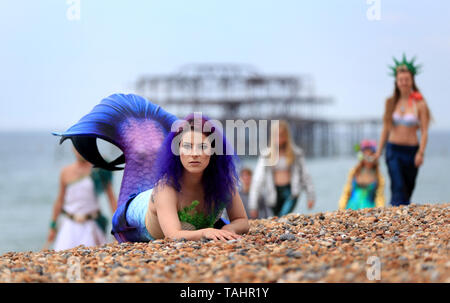 Mermaid Jasz Vegas verbunden ist, die von anderen Meerjungfrauen am Strand während das wechselhafte Wetter in Brighton als Sea Life Brighton kennzeichnet die Öffnung ihrer Tag/Nacht erleben. Stockfoto